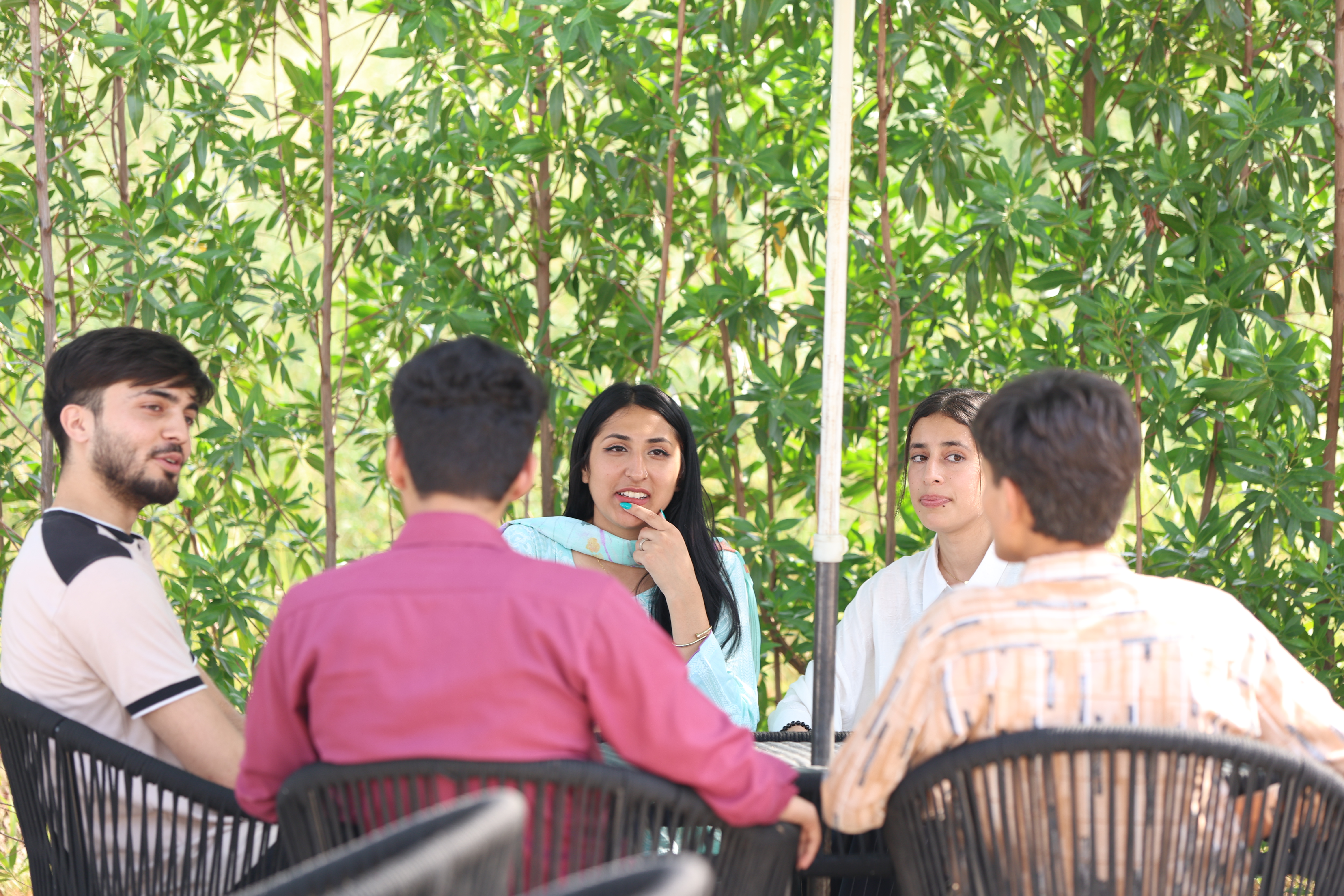 UOR students having a discussion in an outdoor campus seating area